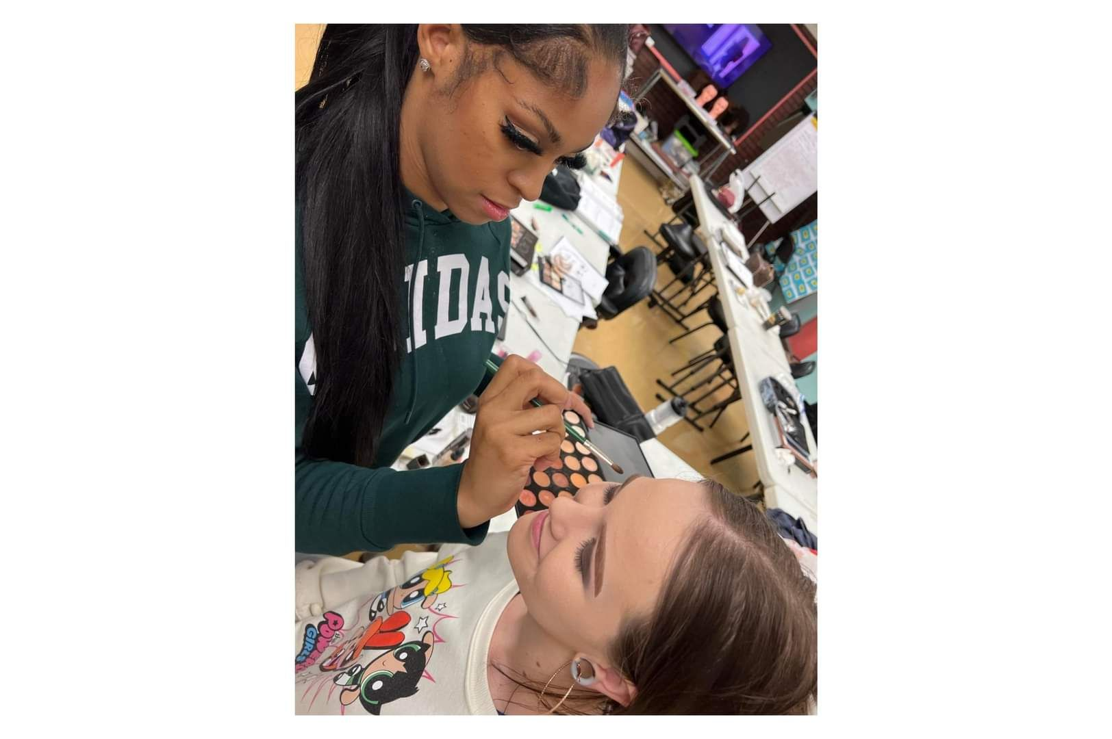 A woman is getting her nails done by another person.