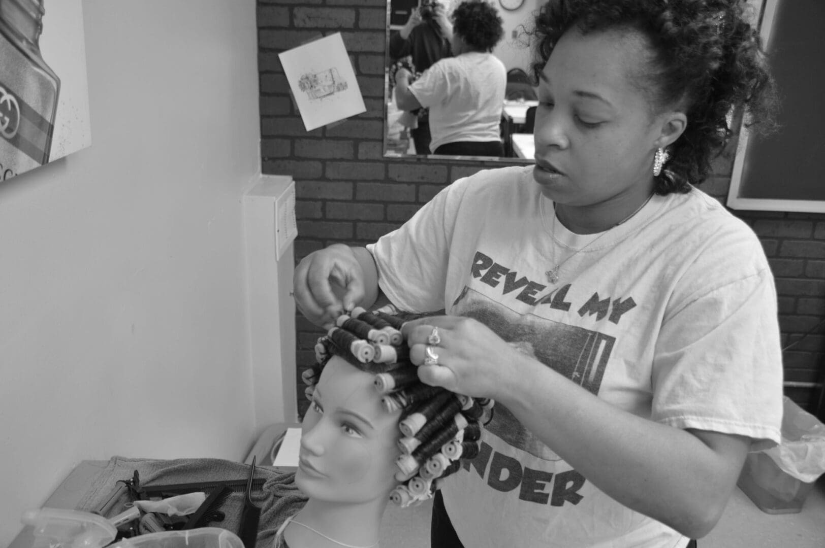 A woman is getting her hair done by another person.
